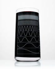 A Cognitive Surplus wine glass with a wave pattern on it.